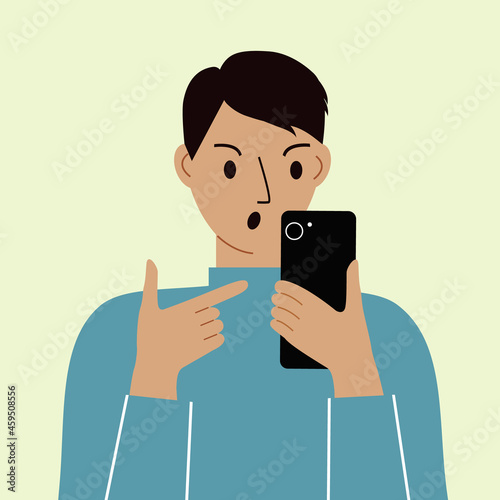 Angry man with mobile phone, front view. Indicates the phone. News. Smartphone and internet addiction.