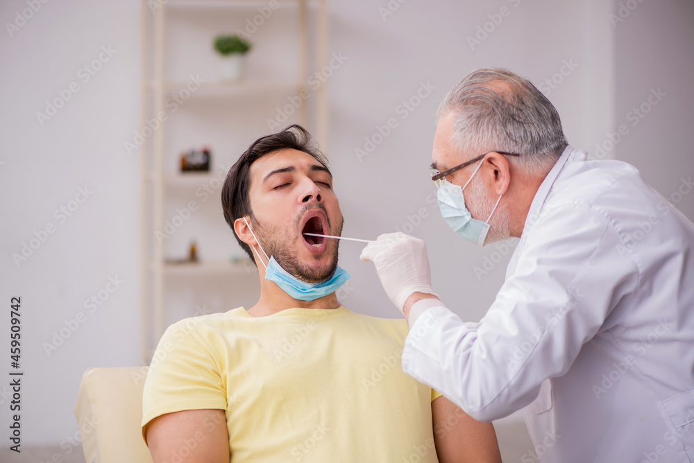 Fototapeta premium Young male patient visiting old male doctor otorhinolaryngologis