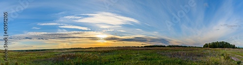 Panoramic sunset landscape in the blue sky over the autumn field