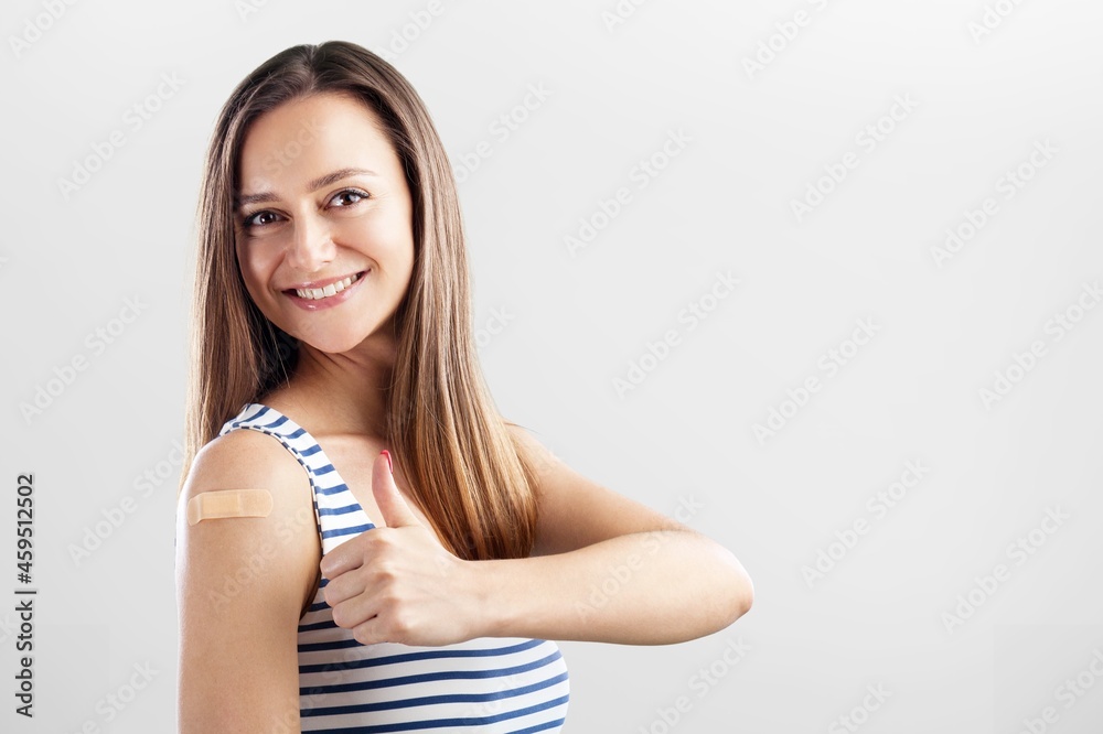 Happy Women Feels Good And Shows Bandage On Arm After Received Covid-19 Vaccine. Thumb up. Happy Women Feels Good And Shows Bandage On Arm After Received Covid-19 Vaccine. Thumb up.