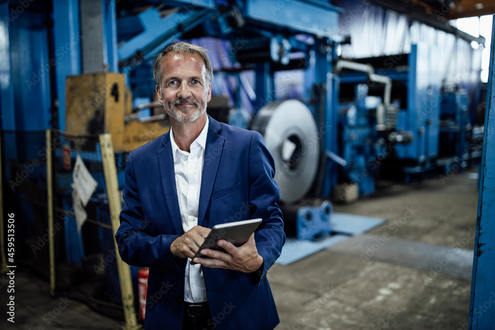 Senior male inspector with digital tablet at steel mill Senior male inspector with digital tablet at steel mill