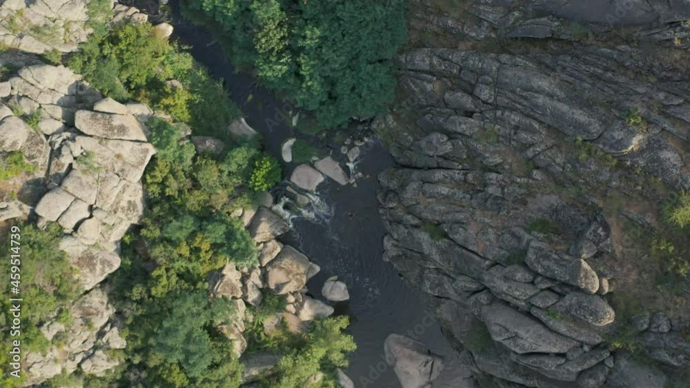 Aktovsky canyon of the Mertvovod river from a bird's eye view. Drone shooting white stone, green trees, cloudy blue sky, a shallow river flows at the bottom of the canyon. Aktovsky canyon of the Mertvovod river from a bird's eye view. Drone shooting white stone, green trees, cloudy blue sky, a shallow river flows at the bottom of the canyon.