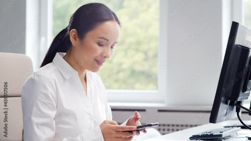 Asian business woman working at her table in a modern office. The workplace of a successful specialist. Business and finance concept. Asian business woman working at her table in a modern office. The workplace of a successful specialist. Business and finance concept.