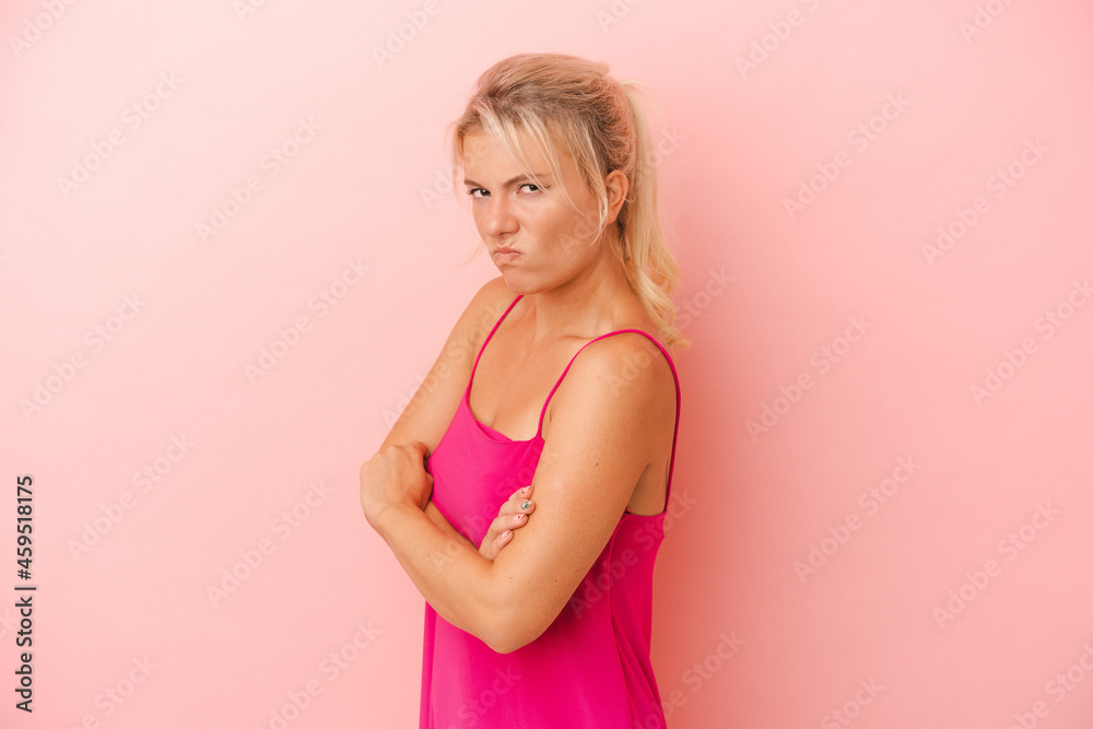 Young Russian woman isolated on pink background frowning face in displeasure, keeps arms folded. Young Russian woman isolated on pink background frowning face in displeasure, keeps arms folded.