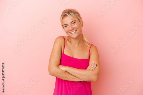 Young Russian woman isolated on pink background who feels confident  crossing arms with determination.