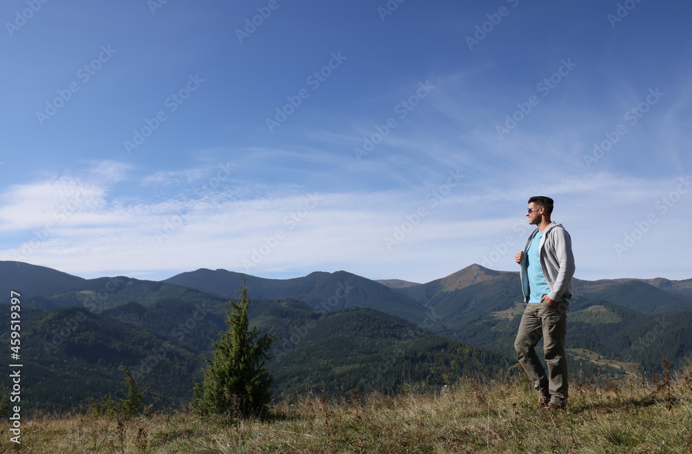 Man enjoying picturesque view of mountain landscape on sunny day