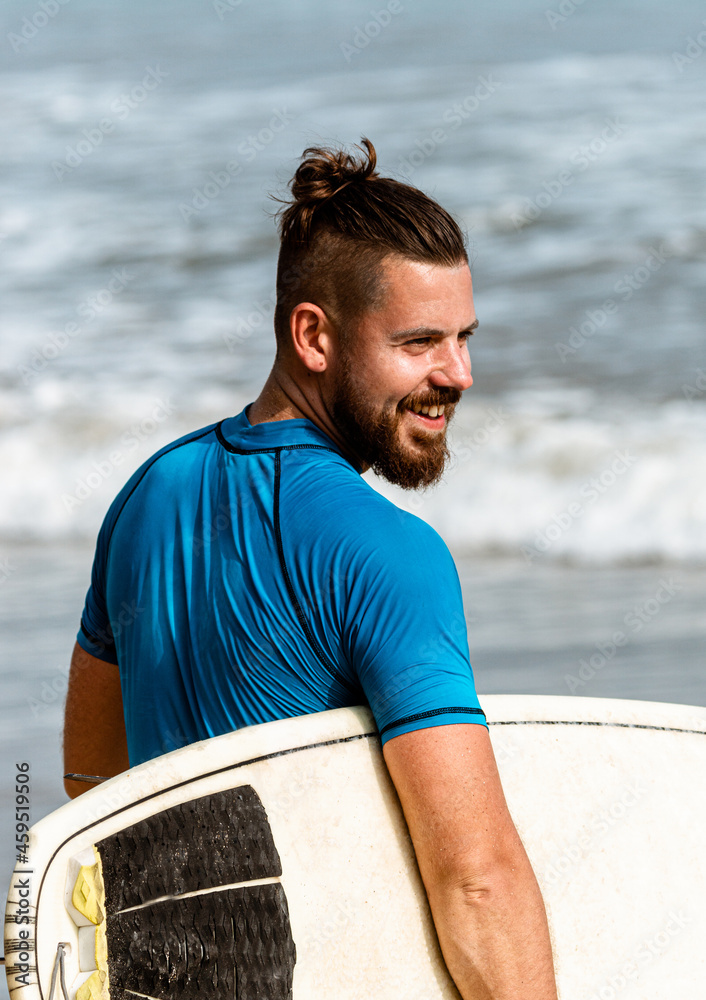 Obraz na płótnie Surfer z deską na wybrzeżu przygotowujący się do pływania. w salonie