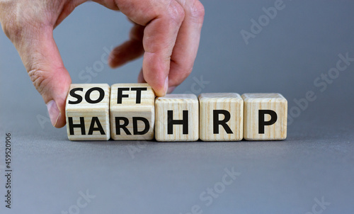 HRP, human resource planning symbol. Businessman turns wooden cubes and changes words hard HRP to soft HRP. Beautiful grey background. Business, HRP, human resource planning concept. Copy space.