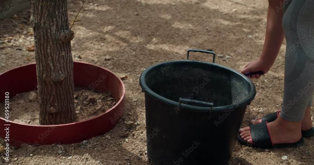 Close up of young farm woman is cleans chicken coop from poos and kids walking around her in rustic house in Catalonia, Spain Close up of young farm woman is cleans chicken coop from poos and kids walking around her in rustic house in Catalonia, Spain