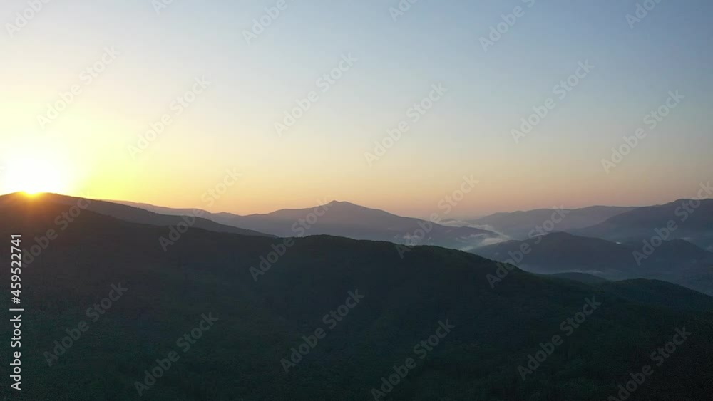 Peaks of the Carpathian Mountains at sunset. Sunset in the mountains, top view. Forest and mountains from a bird's eye view. Mountain range and green valley. Peaks of the Carpathian Mountains at sunset. Sunset in the mountains, top view. Forest and mountains from a bird's eye view. Mountain range and green valley.