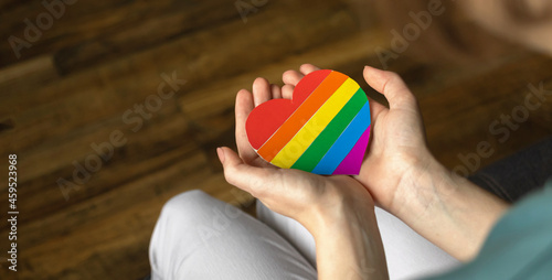 Banner, hands with LGBT rainbow symbol. Colorful heart close-up. LGBTQ, lesbian and gay rights, pride month and tolerance background