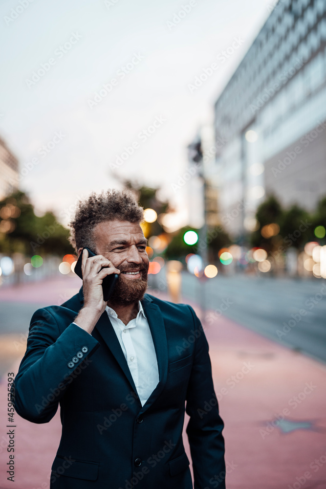 Mature businessman smiling while talking on mobile phone Mature businessman smiling while talking on mobile phone