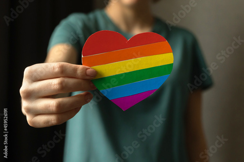 Teenager girl holding heart in LGBT rainbow colors. Pride month, gay and lesbian tolerance conceot background photo photo