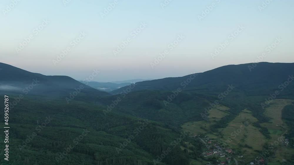 Peaks of the Carpathian Mountains at sunset. Sunset in the mountains, top view. Forest and mountains from a bird's eye view. Mountain range and green valley. Peaks of the Carpathian Mountains at sunset. Sunset in the mountains, top view. Forest and mountains from a bird's eye view. Mountain range and green valley.