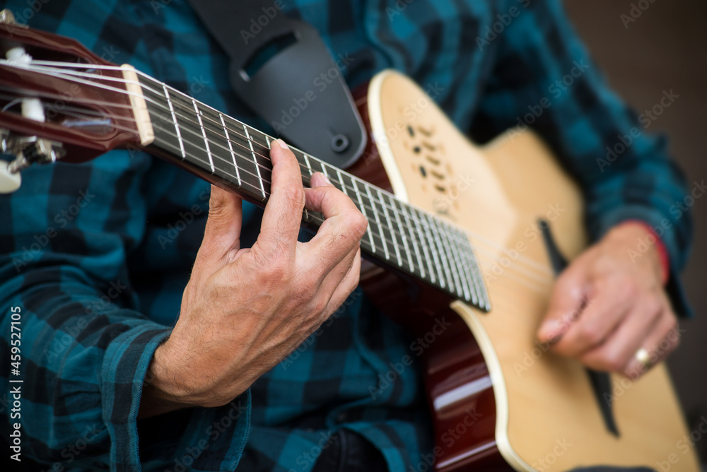Closeup of hands of musician playing guitar in the street Closeup of hands of musician playing guitar in the street