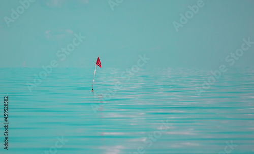 Red flag marking fishing net in the water