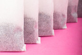 Indian black tea bags close-up on pink background