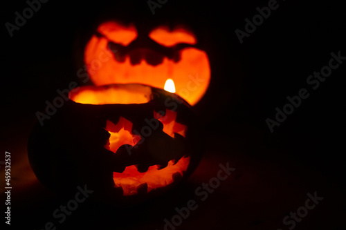 two carved glowing pumpkins with funny faces