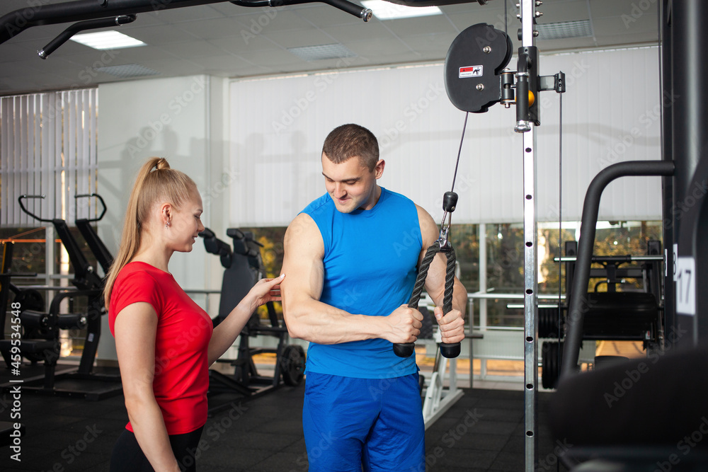Muscles on hands, classes with a coach in gym for teenagers. Treatment of health problems, physical activity. Physical education on simulators. Active lifestyle, concept indoor. Muscles on hands, classes with a coach in gym for teenagers. Treatment of health problems, physical activity. Physical education on simulators. Active lifestyle, concept indoor.