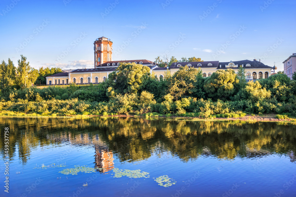 Water tower and reflection in the river in Vologda in the light of a summer evening