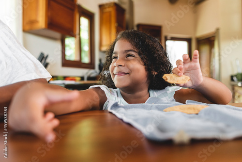 Obraz na plátně Hermosa niña afroamericana con una linda sonrisa comiendo en la mesa de su casa