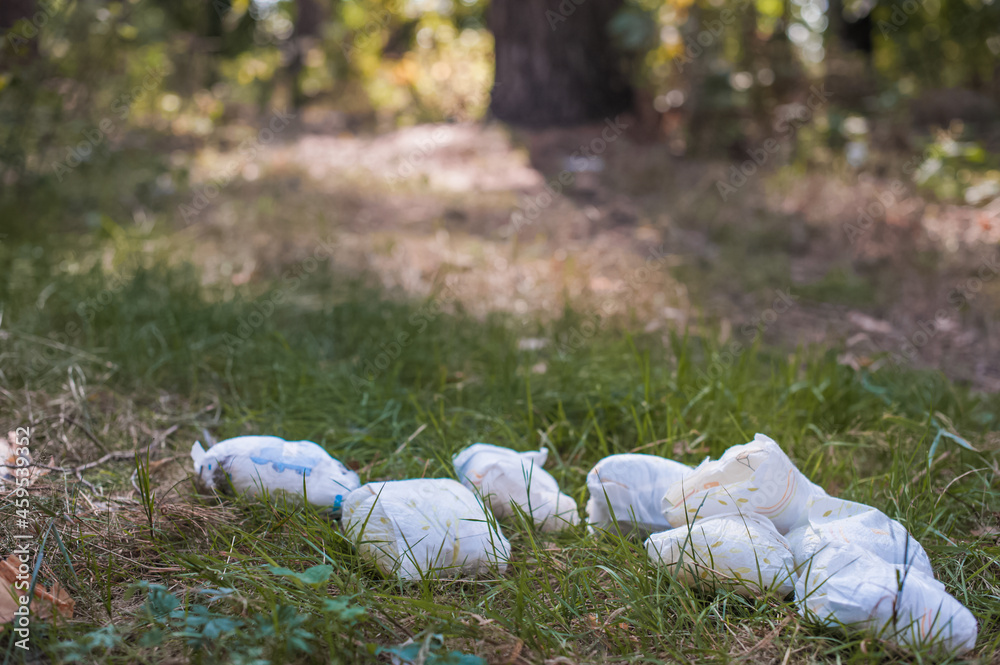 Diapers waste, dirty diapers in nature. Disposing of used baby nappies. Environmental Impact of Disposable Diapers. Pollution of the environment, soil and water. Diapers waste, dirty diapers in nature. Disposing of used baby nappies. Environmental Impact of Disposable Diapers. Pollution of the environment, soil and water.