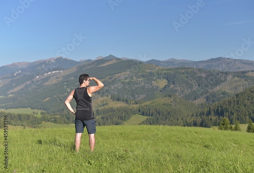 man in sportswear is looking at the mountain landscape