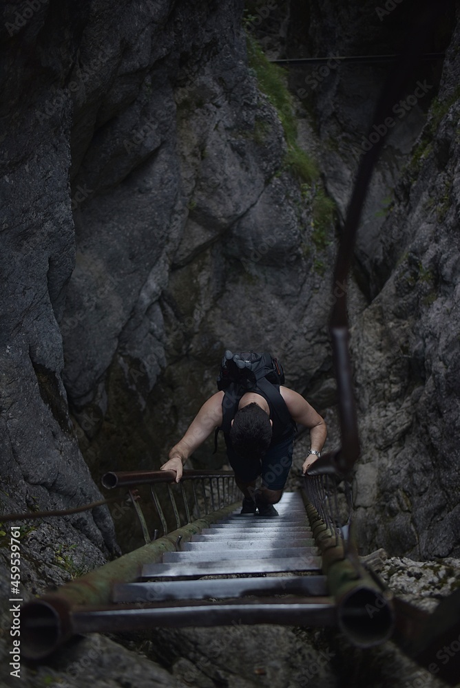 man climbs a tourist ladder in a canyon. Slovakia Central Europe man climbs a tourist ladder in a canyon. Slovakia Central Europe