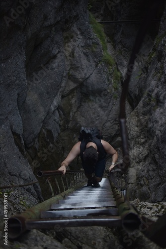 man climbs a tourist ladder in a canyon. Slovakia Central Europe