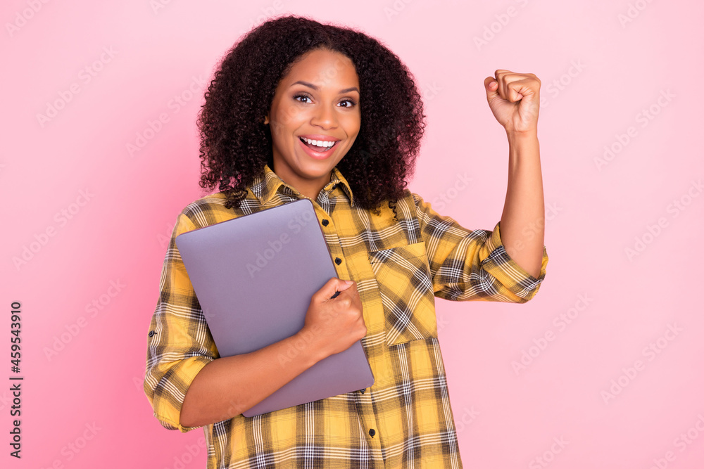 Photo of cheerful lady hold netbook gadget raise fist rejoice wear checkered shirt isolated pink color background Photo of cheerful lady hold netbook gadget raise fist rejoice wear checkered shirt isolated pink color background