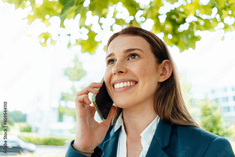 Happy young businesswoman with brown hair talking on smart phone Happy young businesswoman with brown hair talking on smart phone