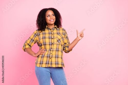 Photo of promoter lady direct forefinger empty space look up wear plaid shirt isolated pink color background
