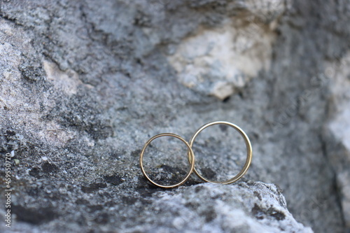beautiful wedding rings on a background of stones. Rock quartz rock and gold wedding rings male and female rings, a symbol of love
