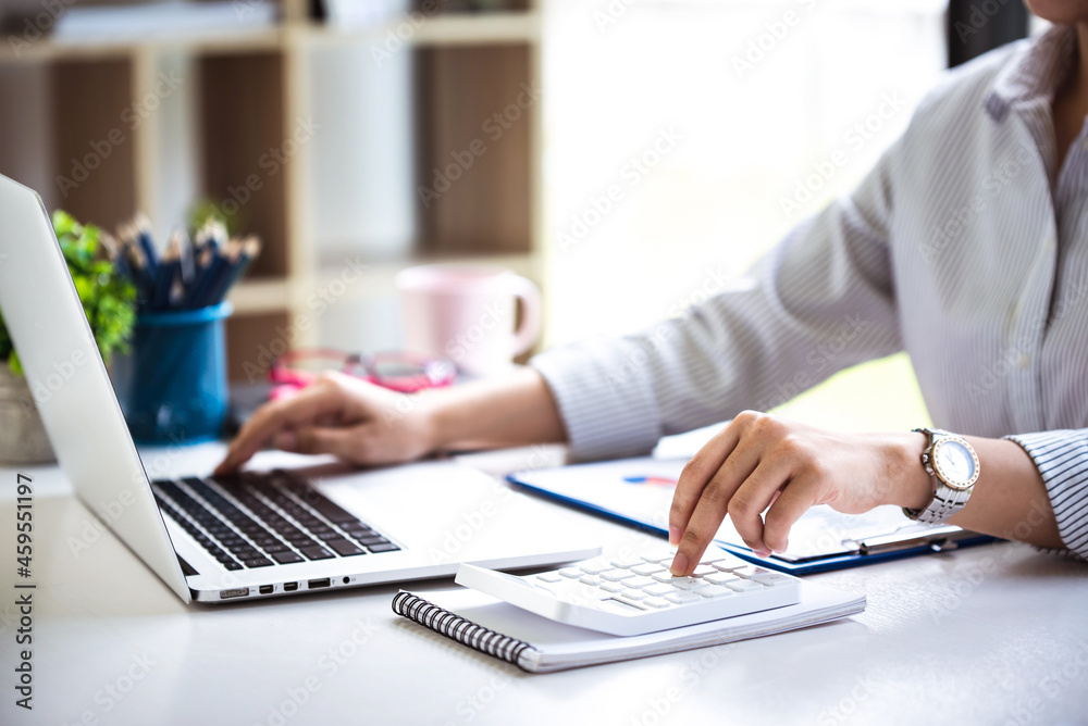 businessman or accountant who are using a calculator to calculate business data Accounting documents and laptop computer at the office business idea businessman or accountant who are using a calculator to calculate business data Accounting documents and laptop computer at the office business idea