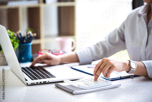 businessman or accountant who are using a calculator to calculate business data Accounting documents and laptop computer at the office business idea