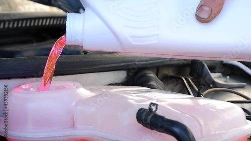 topping up antifreeze.coolant antifreeze.refueling of coolant in the car.topping up red coolant from conistra.