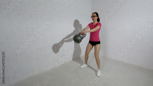 Young beautiful woman doing kettlebell swing. Fitness concept. Workout.