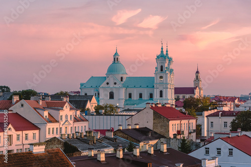 View of the roofs of Grodno under the scarlet sky and the Farny Church in the light of sunset. Grodno is a city in the west of Belarus