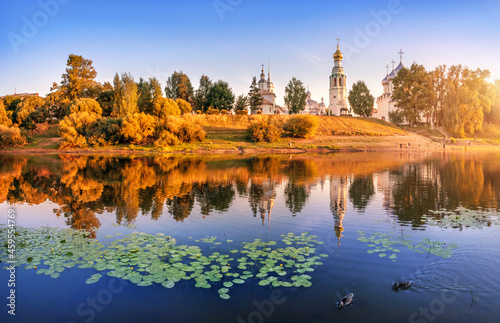 Kremlin temples and water lilies and ducks in the river in Vologda in the light of a summer evening