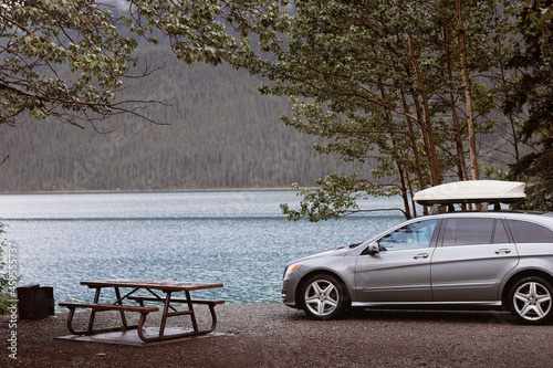 Foto lakeside campsite with picnic table fire pit ring and campvan, raining day cloud