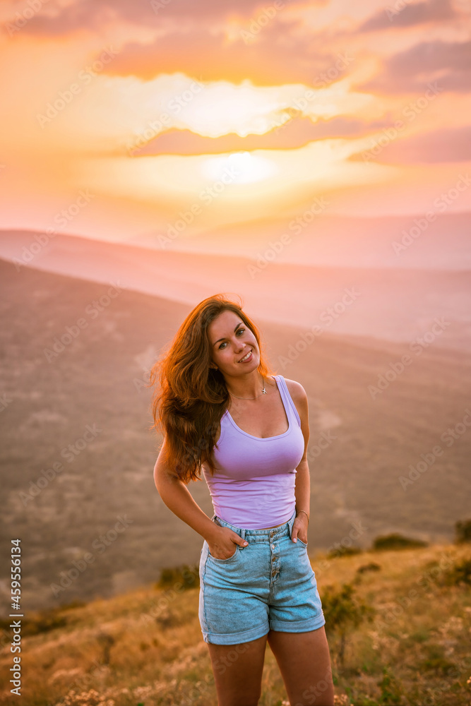 Beautiful slender woman on top of a mountain at sunset. Amazing landscape with a gradient of mountains. The concept of sports and active life. Beautiful slender woman on top of a mountain at sunset. Amazing landscape with a gradient of mountains. The concept of sports and active life.