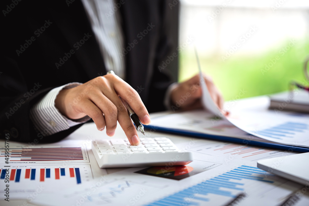 A young woman's hand presses a calculator to determine and summarize the cost of mortgage home loans for refinancing plans, lifestyle concepts. A young woman's hand presses a calculator to determine and summarize the cost of mortgage home loans for refinancing plans, lifestyle concepts.