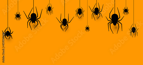 Hanging spiders halloween orange background.