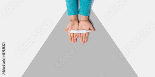 Woman holding a positive pregnancy test - overhead view