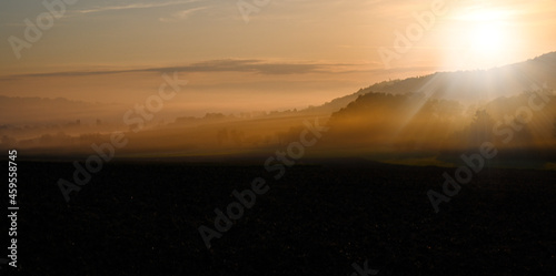 Sunrise in front of the mountains and valleys with fog over the field farming countryside or landscape.