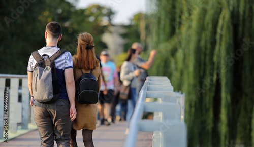 Para młodych ludzie, kobieta i mężczyzna z plecakami spaceruje po moście we Wrocławiu.	
