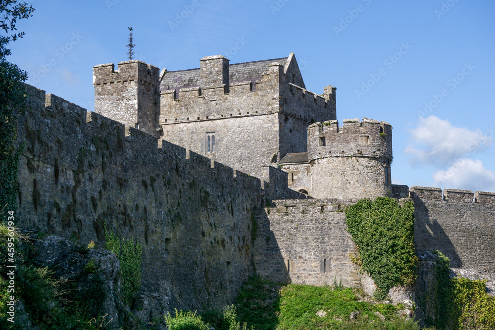 old big castle in irland with blue sky and some green plants on the walls