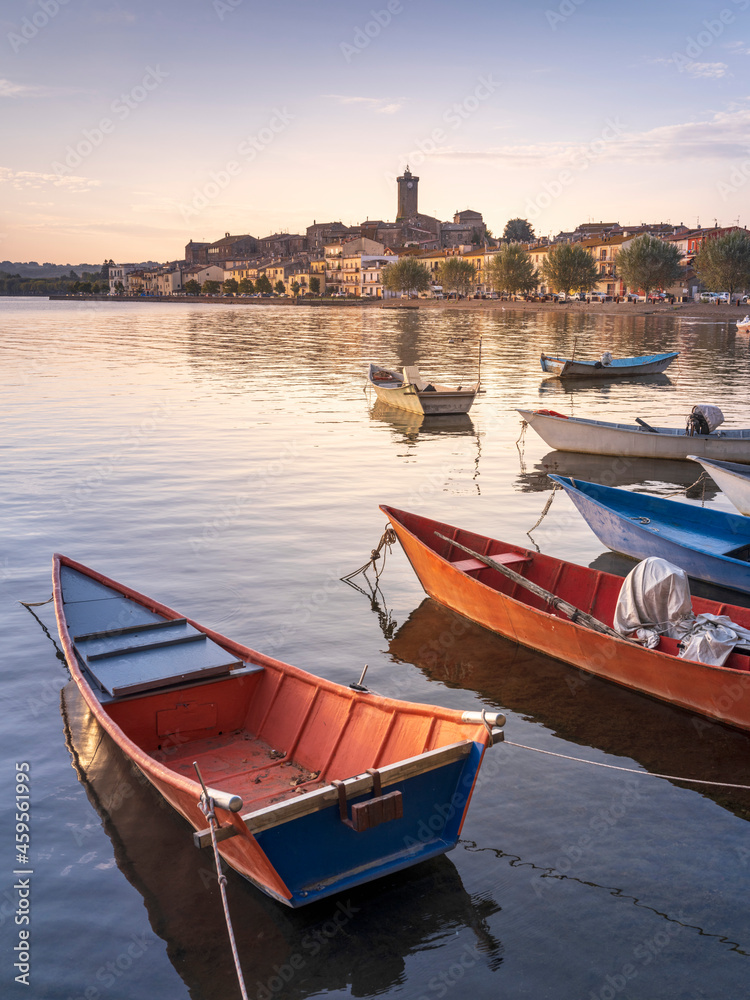 six fishing boats on lake Bolsena and view to city Marta in Italy