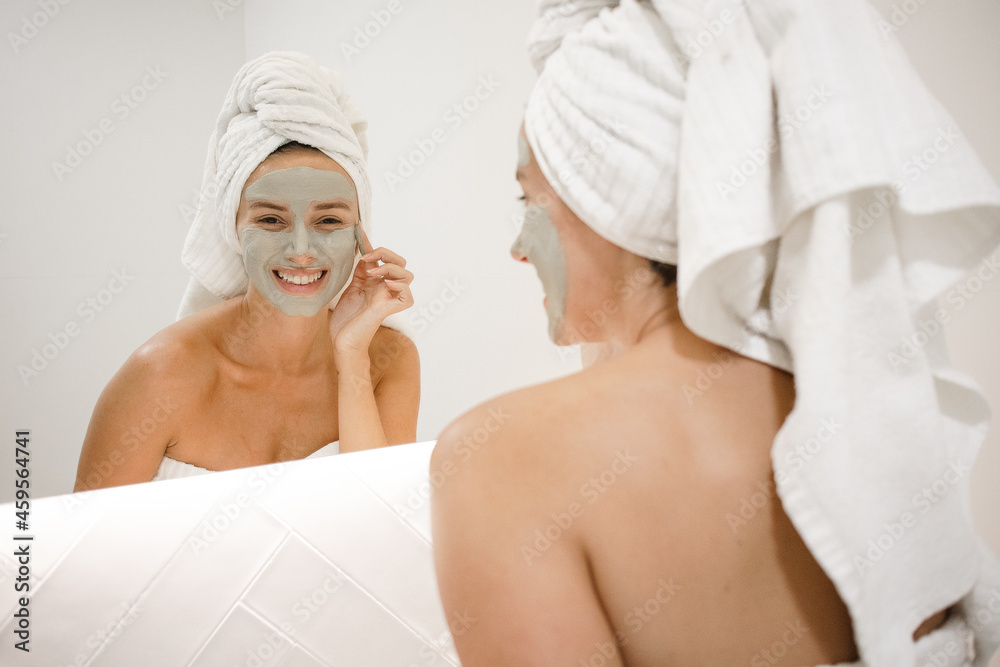 young white woman applying green clay mask bathroom mirror anti acne anti aging spots signs of age oily skin treatment after shower self care skin care young adult cosmetics plump toned spotless skin young white woman applying green clay mask bathroom mirror anti acne anti aging spots signs of age oily skin treatment after shower self care skin care young adult cosmetics plump toned spotless skin