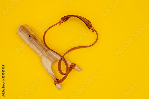 Wooden slingshot isolated on yellow background